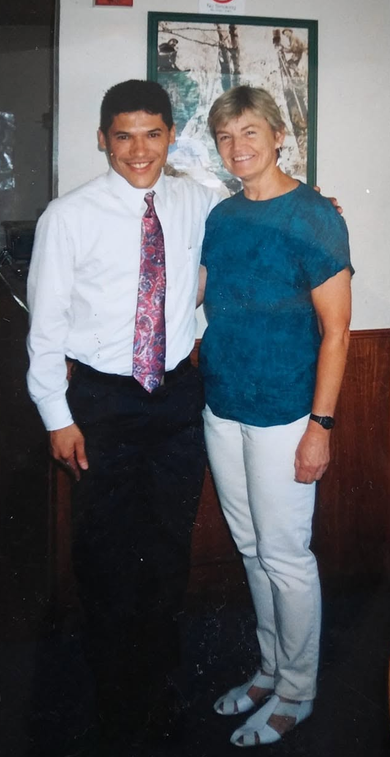 Jorge Orrantia, con camisa blanca y corbata, y Sandy Kobrine, con blusa verde azulada, de pie uno al lado del otro y sonriendo.
